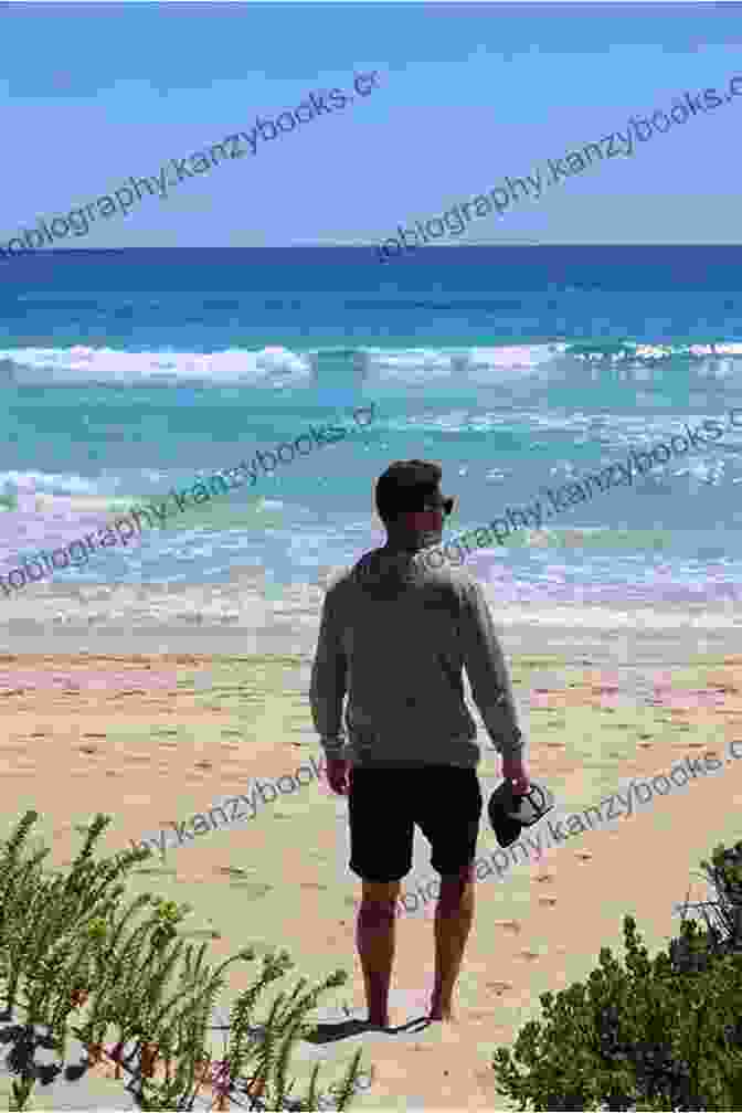 A Man Sitting On A Beach, Looking Out At The Vast Expanse Of The Ocean. Cancer: A Memoir